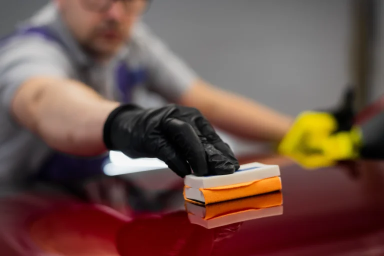 closeup-man-applying-ceramic-coating-red-car-detailing-service